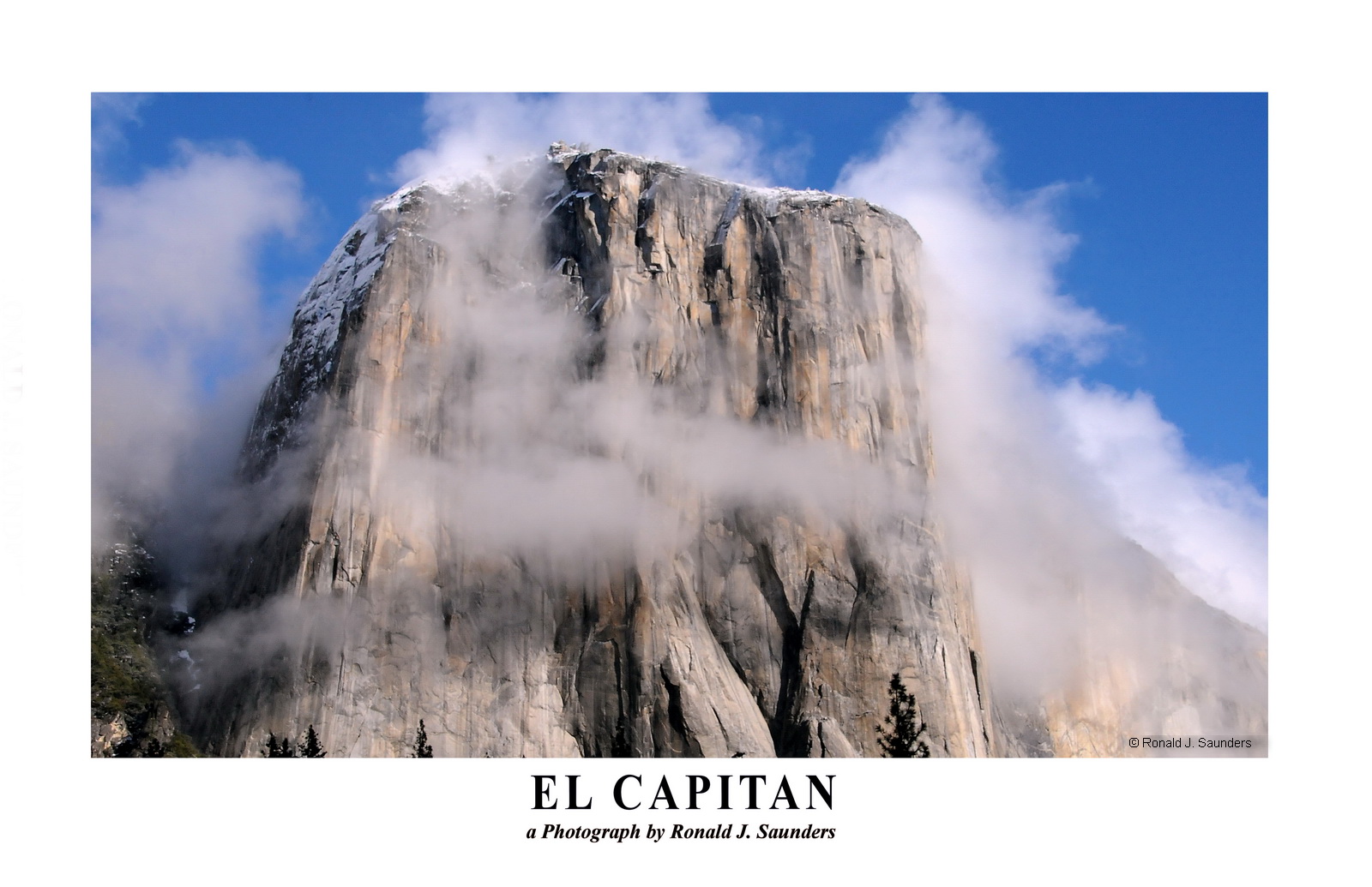 El Capitan is cloaked in clouds during a mid-morning winter.