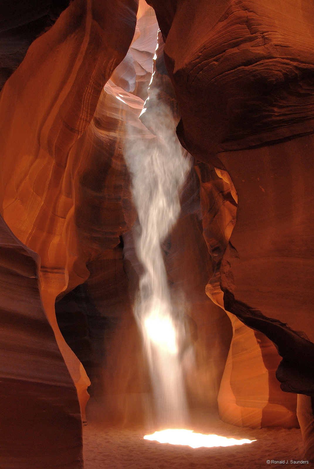 The beams in the slot canyon are created by light reflecting off the dust in the air.